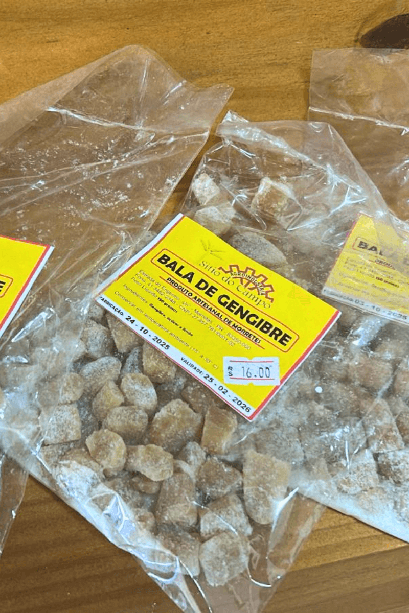 Pacotes de plástico transparente com Balas de Gengibre artesanais cobertas com açúcar, exibindo o rótulo amarelo da marca Sítio do Campo.