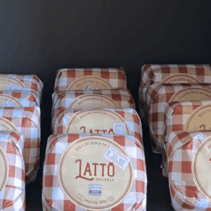 Pacotes de Bala de Doce de Leite da marca Lattô Doceria, peso líquido 300g, com embalagem em padrão xadrez marrom e branco e etiqueta redonda central.
