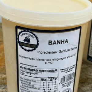 Pote de Banha Suína artesanal da Embutidos São Francisco em destaque, mostrando o rótulo branco e informações nutricionais sobre balcão.