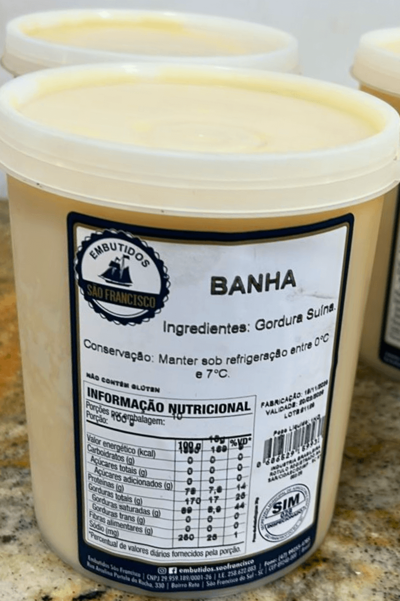 Pote de Banha Suína artesanal da Embutidos São Francisco em destaque, mostrando o rótulo branco e informações nutricionais sobre balcão.