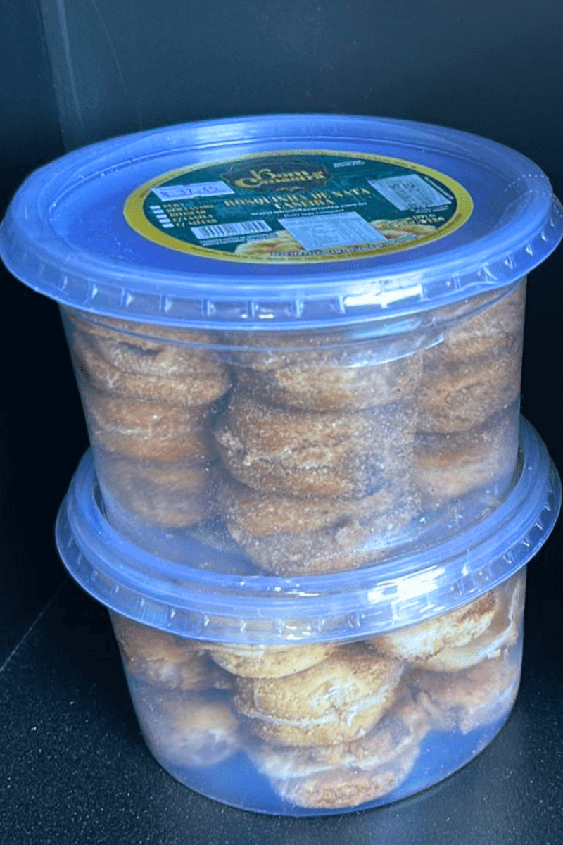 Potes empilhados de Casadinho de Nata Bom da Canastra, mostrando biscoitos amanteigados recheados e polvilhados com açúcar, com rótulo verde destacando a marca.