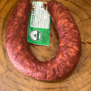 Linguiça Pura Defumada da Embutidos São Francisco em formato de ferradura sobre uma superfície de madeira rústica, destacando a etiqueta verde e branca.