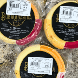 Três unidades do Mix Quatro Queijos Canastra Casa Magnani embaladas a vácuo, mostrando as divisões de Queijo Parmesão, Reino, Prato e Provolone Defumado.