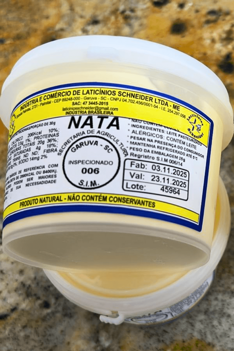 Pote de Nata artesanal da Laticínios Schneider em primeiro plano, mostrando o selo de inspeção 006 e as datas de fabricação e validade.