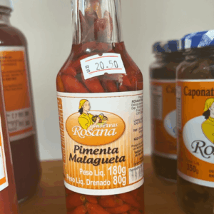 "Frasco de vidro alto de Pimenta Malagueta Rosana de 180g, com tampa vermelha, mostrando as pimentas inteiras e avermelhadas em conserva.