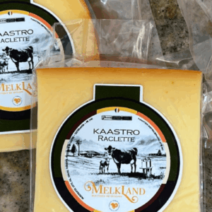 Peças de Queijo Kaastro Raclette da marca Melkland, embaladas a vácuo, com rótulo circular verde e laranja apresentando a ilustração de uma vaca e o nome do produto.