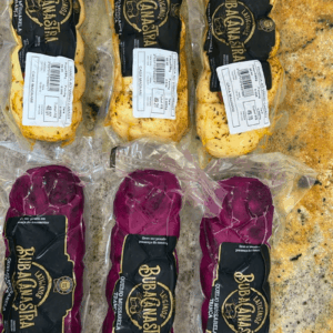 Variedade de Queijo Mussarela Trança BubaCanastra, incluindo versões banhadas ao vinho e versões com tomate seco e ervas, embaladas individualmente a vácuo.
