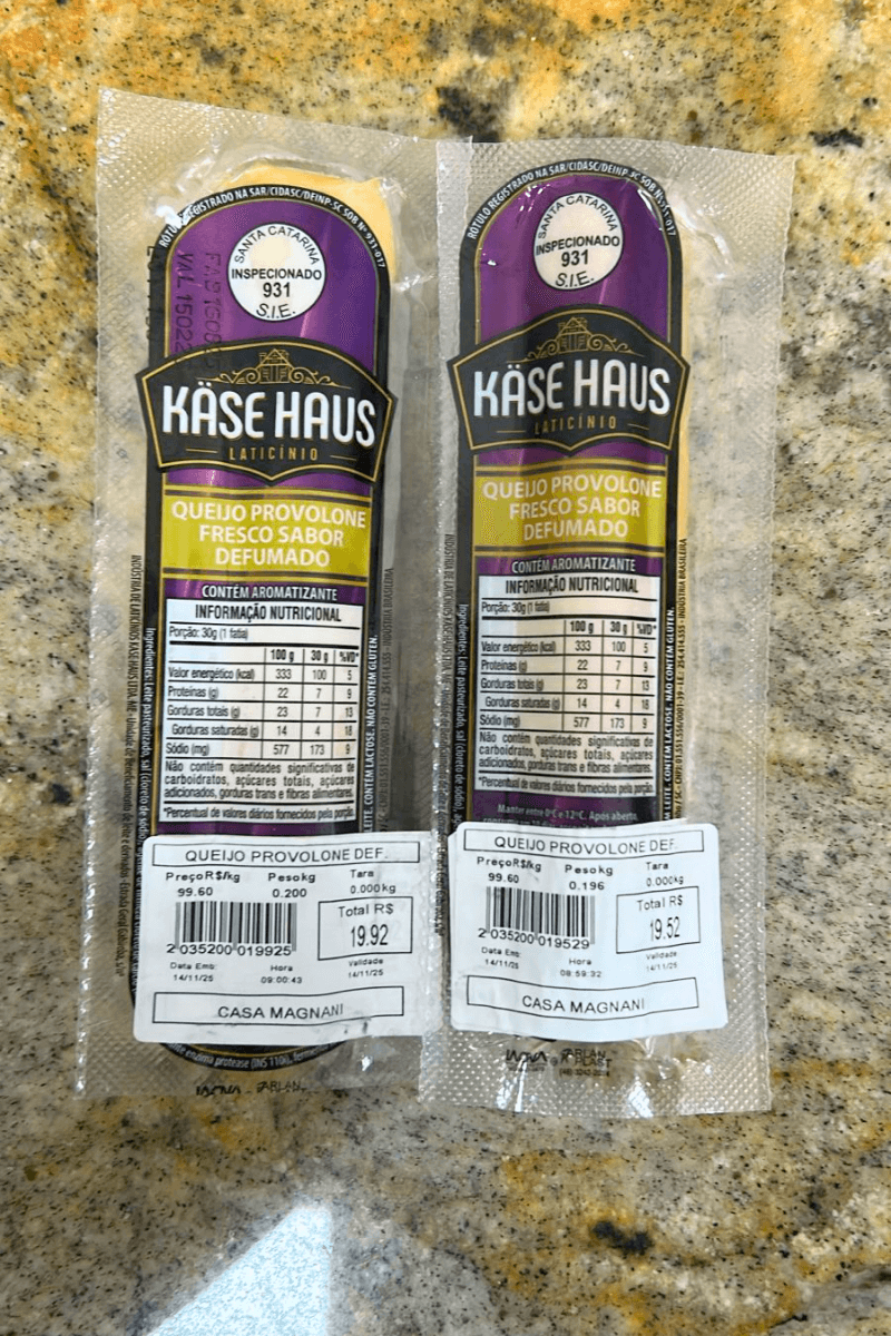 Duas peças de Queijo Provolone Fresco Sabor Defumado da marca Käse Haus, embaladas a vácuo, com rótulo roxo e dourado, destacando o selo de inspeção S.I.E. 931 de Santa Catarina.