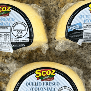 Três peças fracionadas de Queijo Fresco (Colonial) da marca Scoz, embaladas a vácuo, com rótulo azul e branco destacando o selo de inspeção S.I.M. 008 de Pouso Redondo, Santa Catarina.