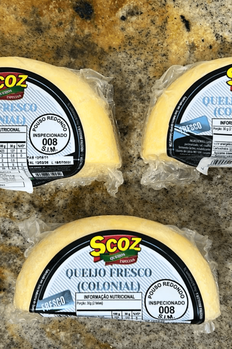 Três peças fracionadas de Queijo Fresco (Colonial) da marca Scoz, embaladas a vácuo, com rótulo azul e branco destacando o selo de inspeção S.I.M. 008 de Pouso Redondo, Santa Catarina.