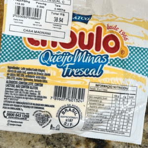 Embalagem de Queijo Minas Frescal da marca Crioulo, com logomarca vermelha e azul, destacando a tradição "Desde 1966", o selo de inspeção federal S.I.F. 2187 e a etiqueta de pesagem da Casa Magnani.