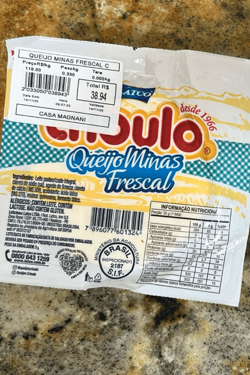 Embalagem de Queijo Minas Frescal da marca Crioulo, com logomarca vermelha e azul, destacando a tradição "Desde 1966", o selo de inspeção federal S.I.F. 2187 e a etiqueta de pesagem da Casa Magnani.
