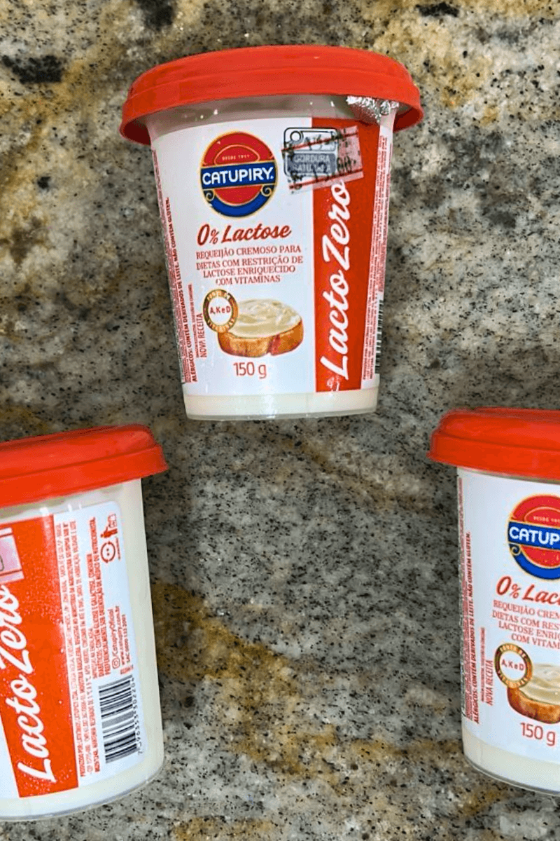 Copo de 150g de Requeijão Cremoso Catupiry Zero Lactose, embalagem branca e vermelha com a inscrição "Lacto Zero" e ícone indicando enriquecimento com vitaminas A, K, E e D.